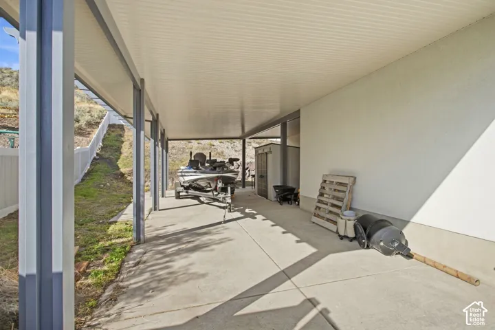 Covered concrete patio with a permanent storage shed