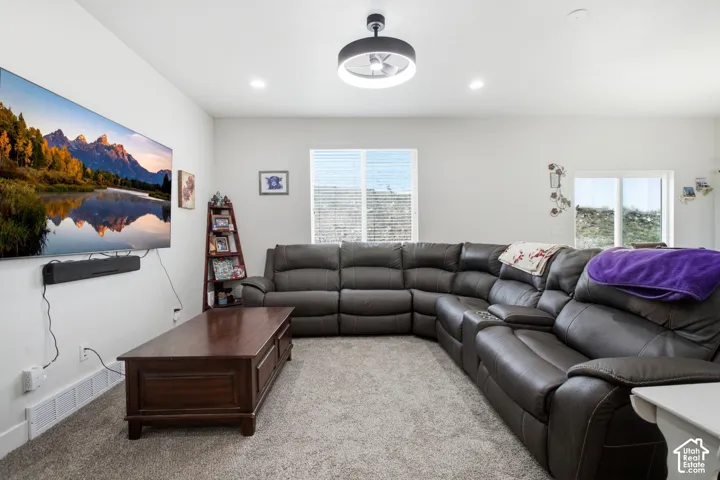 Recessed ceiling lighting complements the central ceiling fixture in this living space