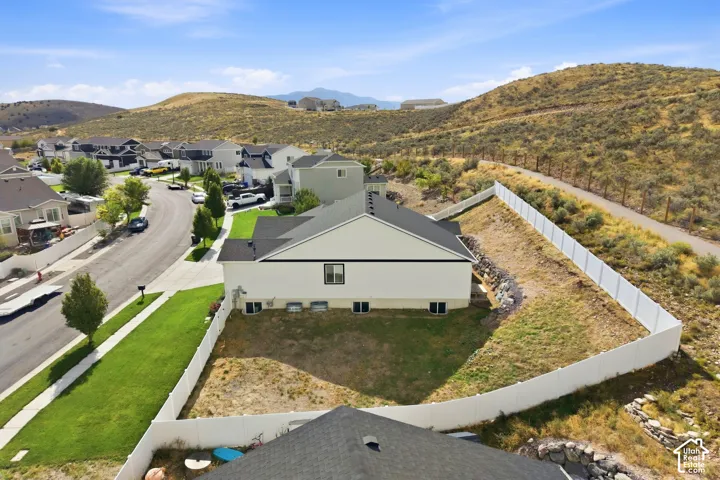 Modern residence with a white exterior, dark-pitched roof, and a fenced backyard