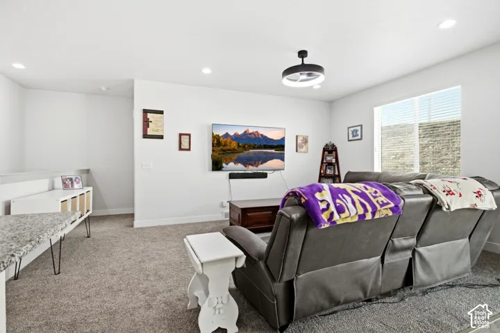 Recessed lighting, contemporary ceiling fixture, carpeting, large window, and built-in half wall with countertop