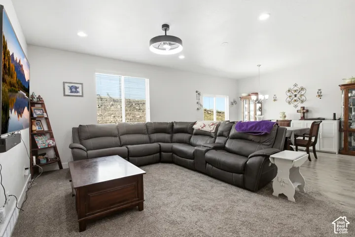 Recessed lighting, ceiling fan, and large windows with blinds
