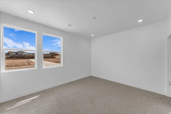 Recessed lighting, light gray carpeting, and white painted walls