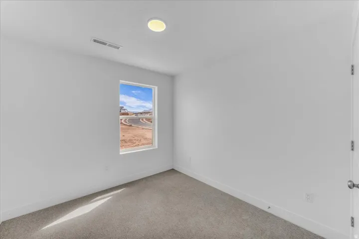 Recessed ceiling lighting, white walls, single window, gray carpeting, and white trim