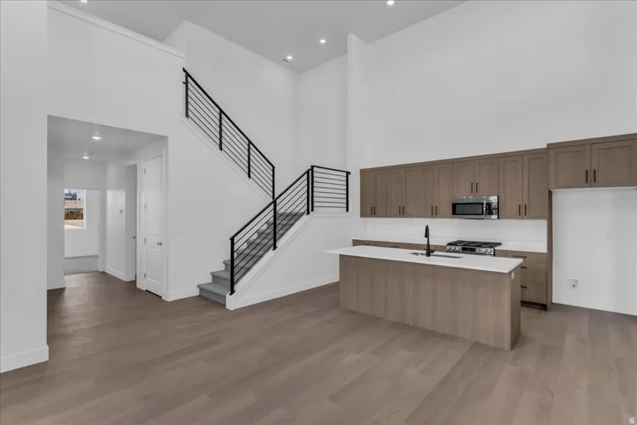 Open-concept kitchen with wood-finish flooring, a central island, and stainless steel appliances