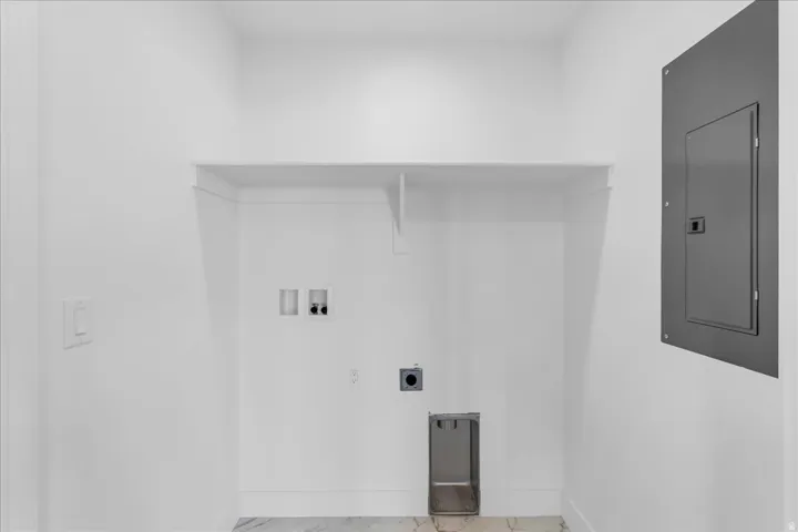 Dedicated laundry area with an integrated shelf, appliance hookups, and a built-in utility basin