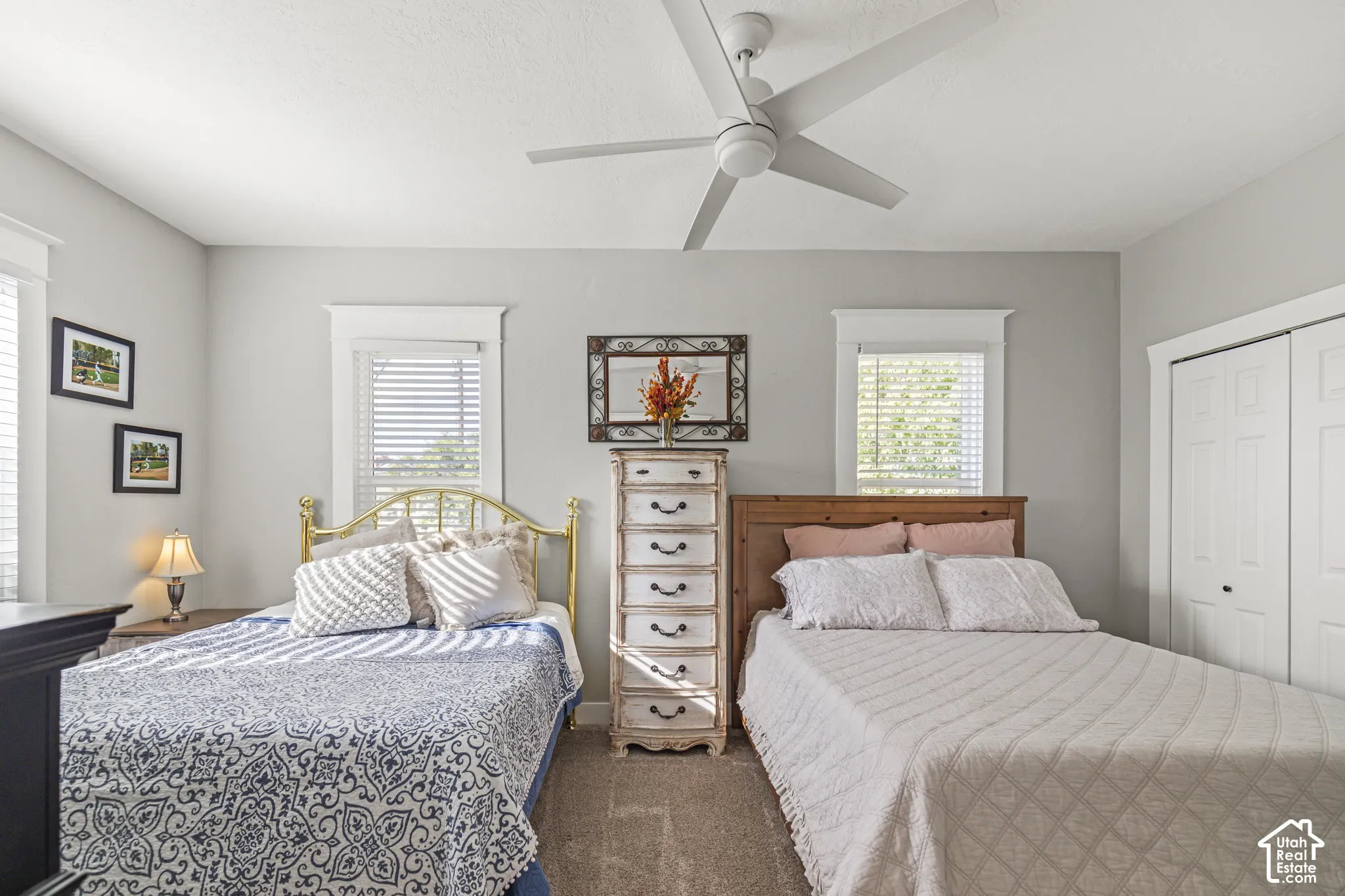 Gray painted walls, white trim details, window with blinds, ceiling fan, bi-fold closet doors