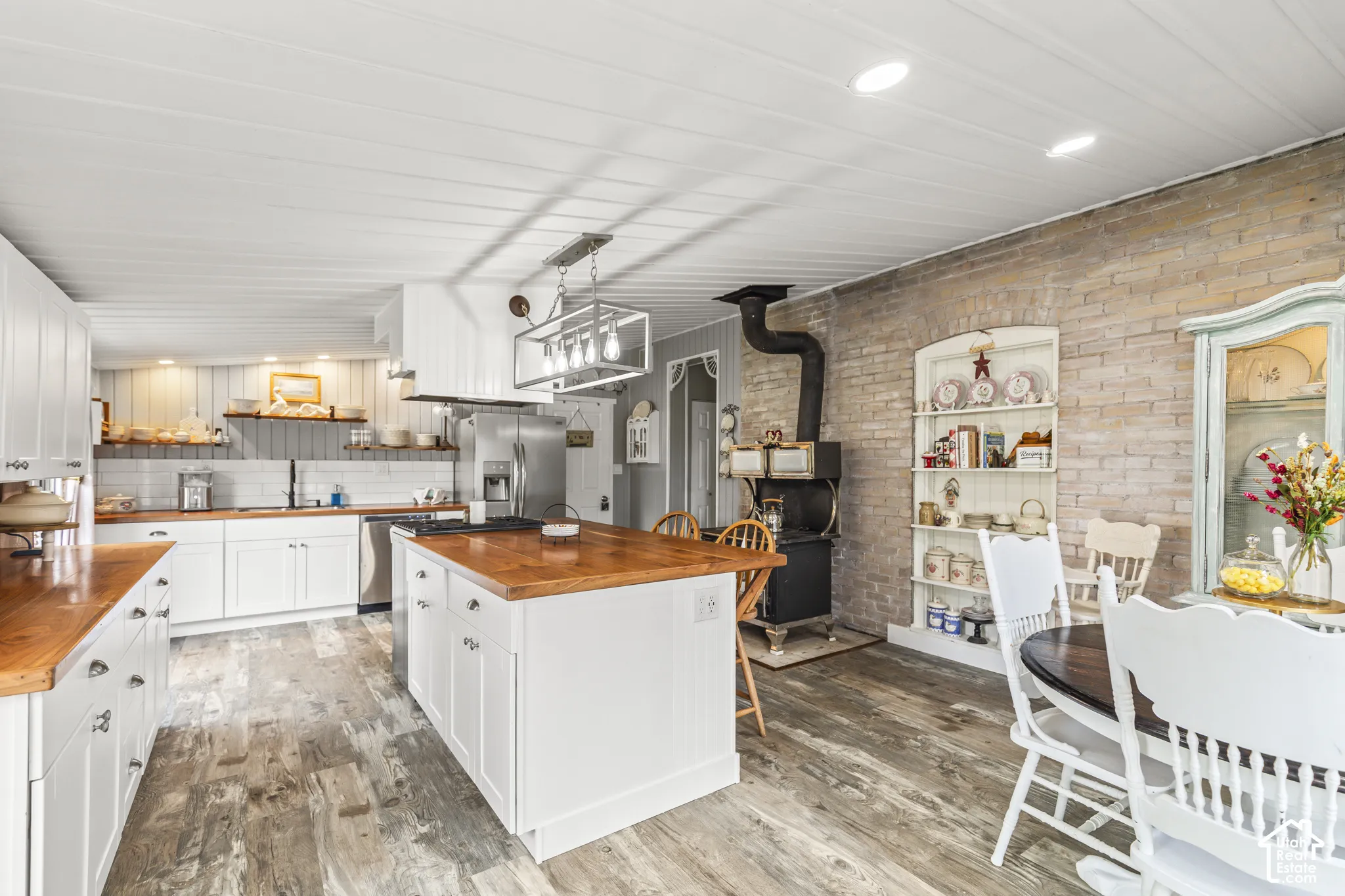 Spacious kitchen featuring white cabinetry, wood-finish countertops, and a central island