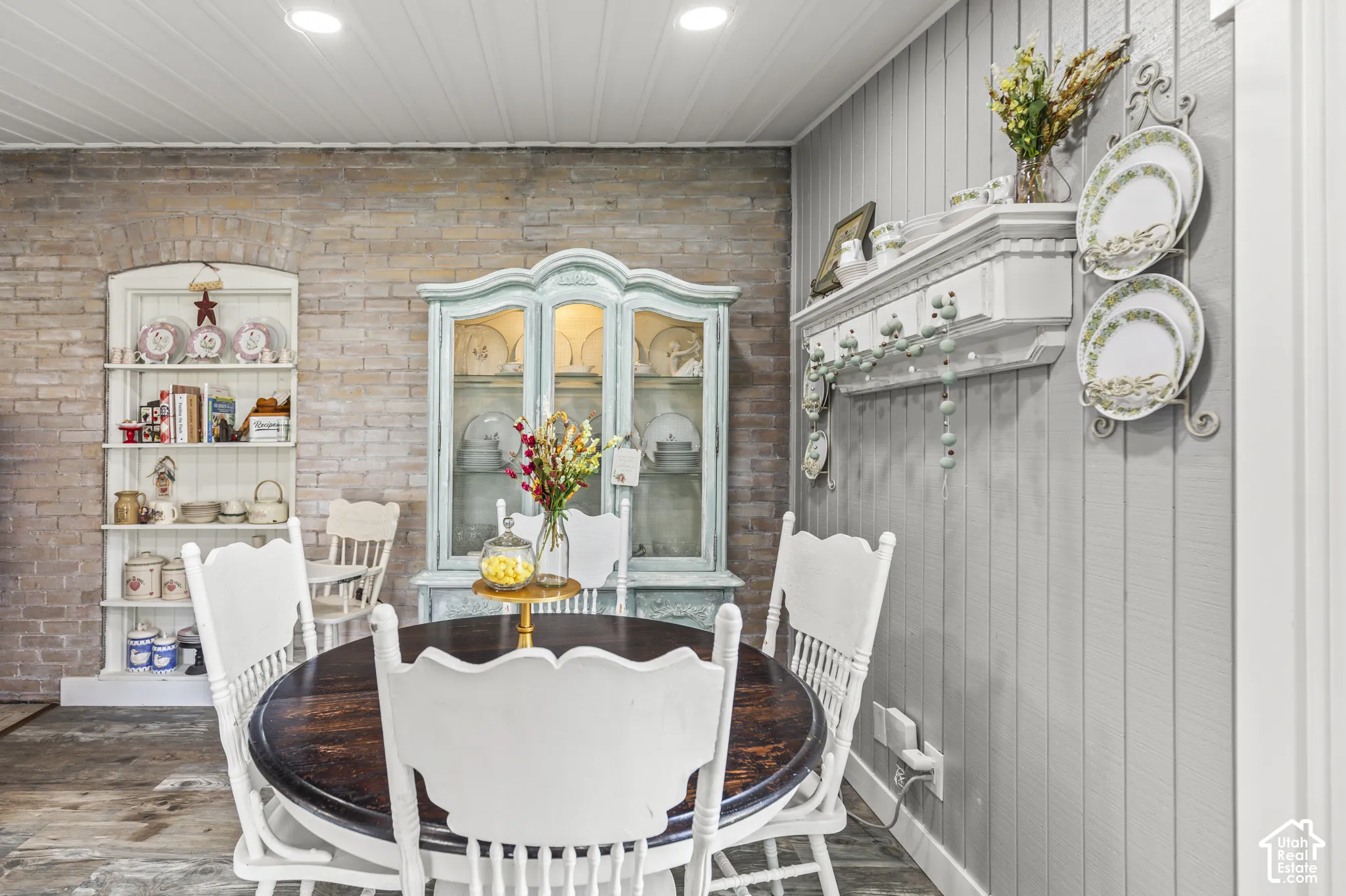 Exposed brick wall, vertical plank wall paneling, recessed lighting, wood-finish flooring, and a white plank ceiling