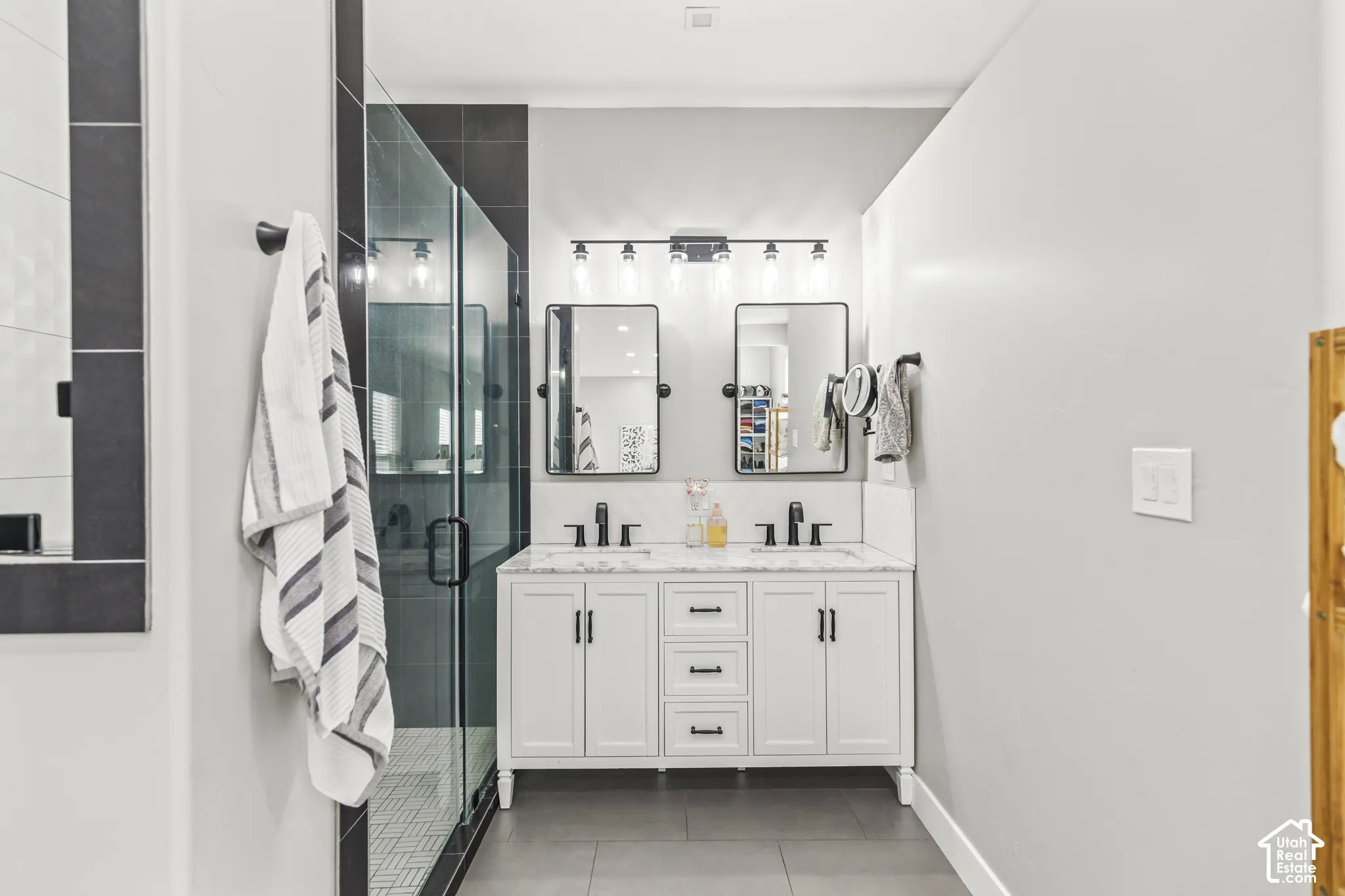 Double vanity with quartz countertop, dual undermount sinks, and matte black fixtures
