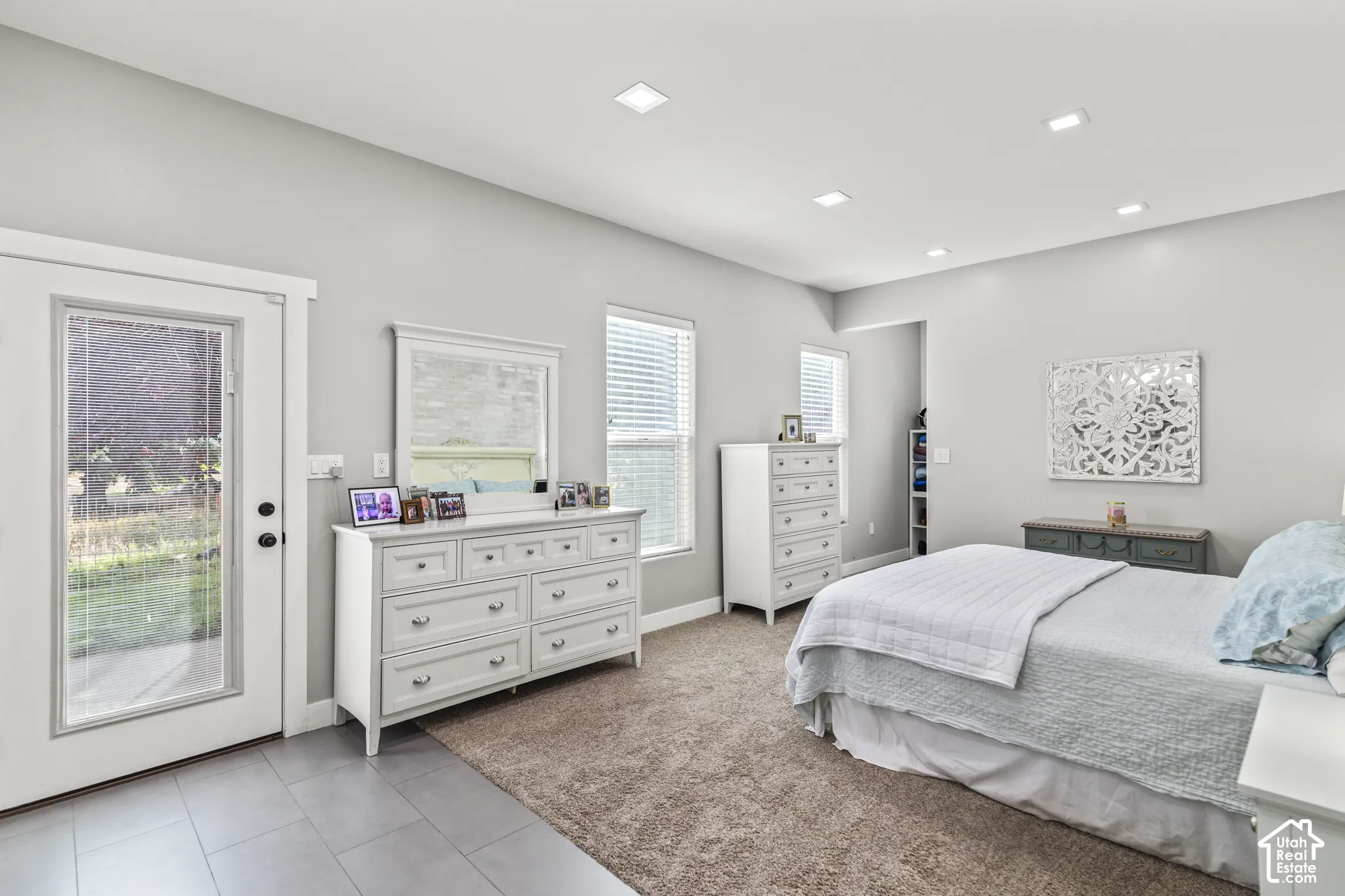 Recessed lighting, light gray walls, multiple windows with blinds, and tile flooring at the entry