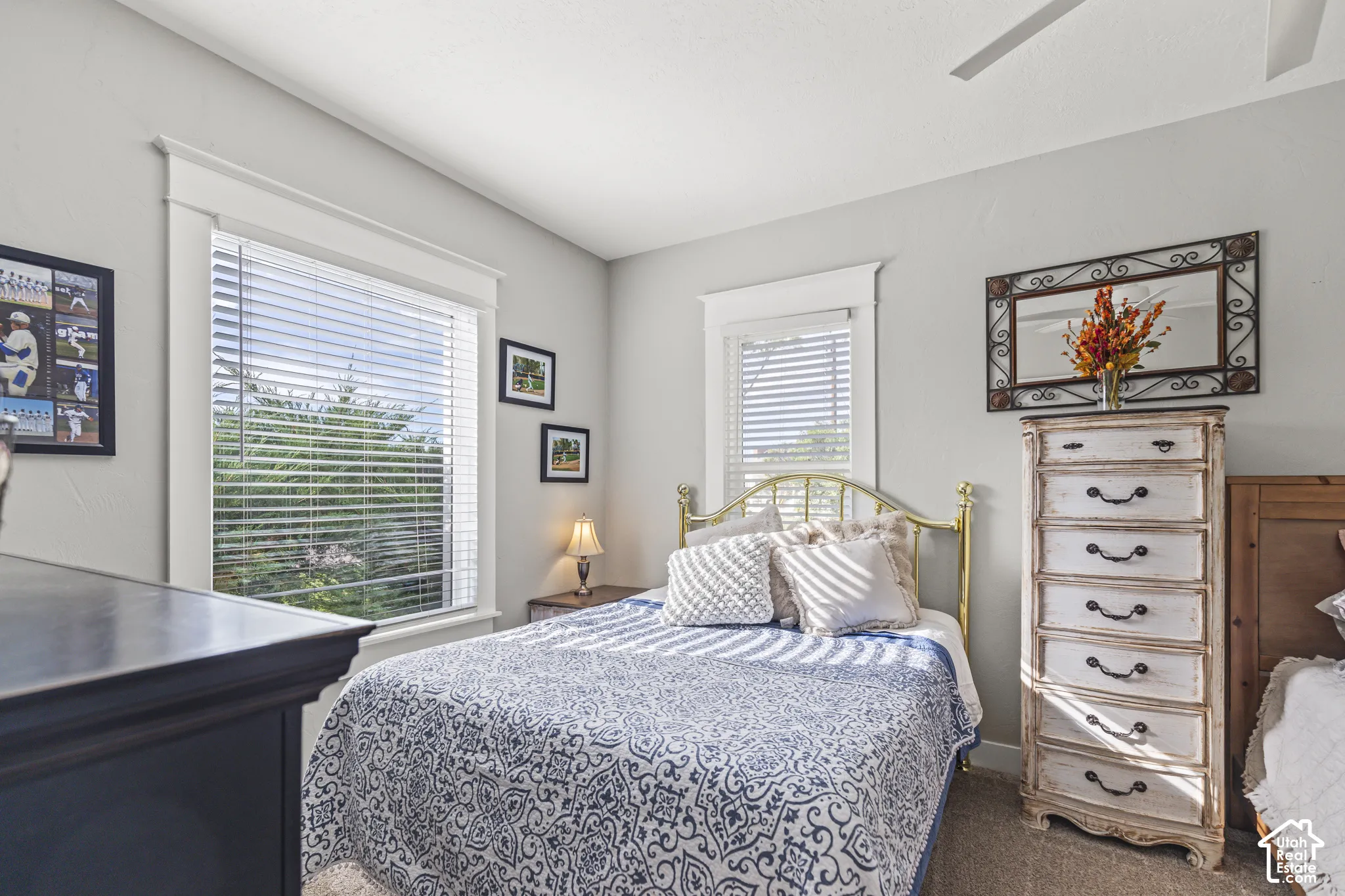 Bright room with two windows, a ceiling fan, and carpeted flooring