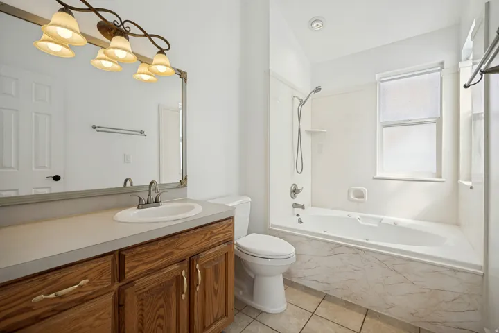 Wood-finish vanity with a single basin sink and brushed nickel faucet