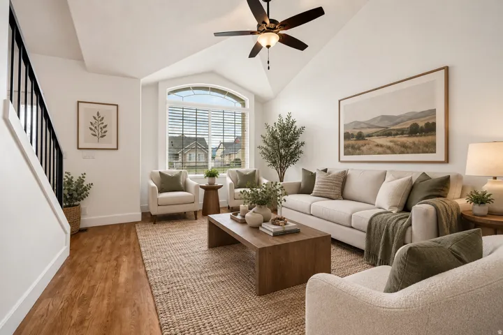 Virtually staged:Vaulted ceiling with a ceiling fan, arched window with horizontal blinds, wood-finish flooring, and white walls