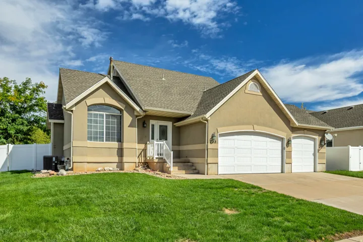 Stucco exterior with a pitched roof, arched window detail, and a multi-car garage