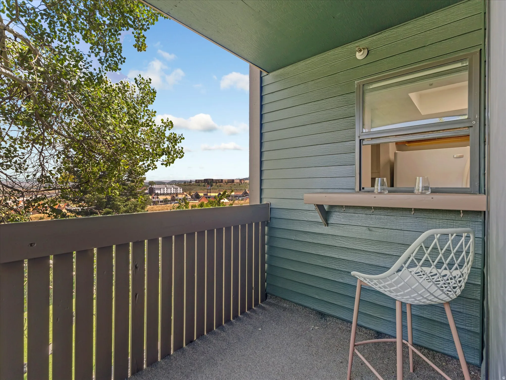 Private balcony with a slatted railing, exterior window, and a built-in shelf
