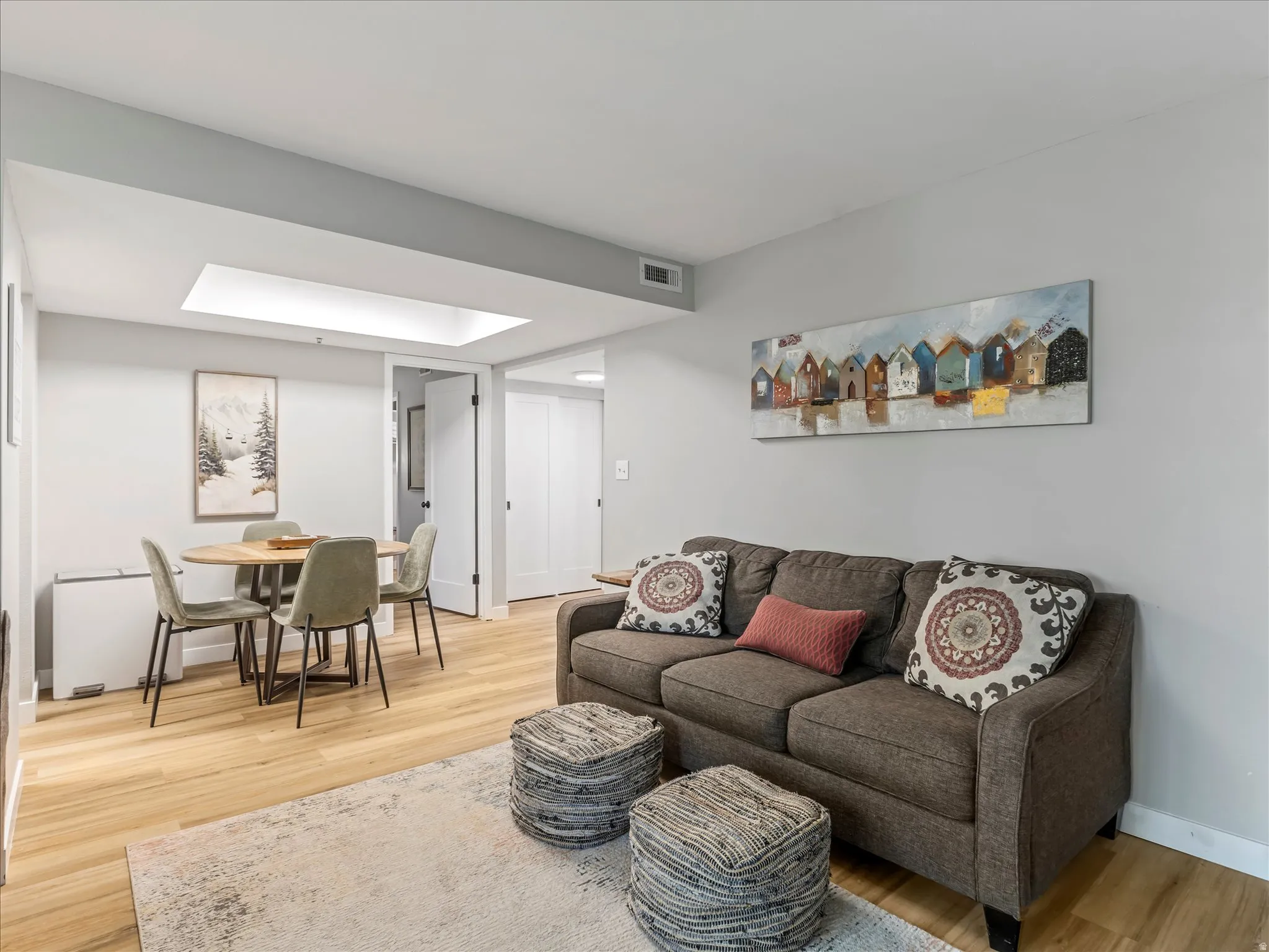 Recessed ceiling lighting, wood-finish flooring, white trim, and a white interior door