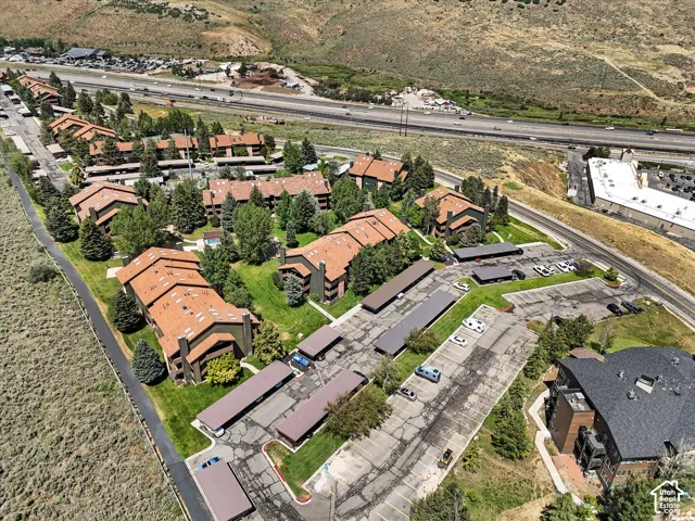 Multi-building complex with brown-toned roofs, surrounded by green landscaping and mature trees