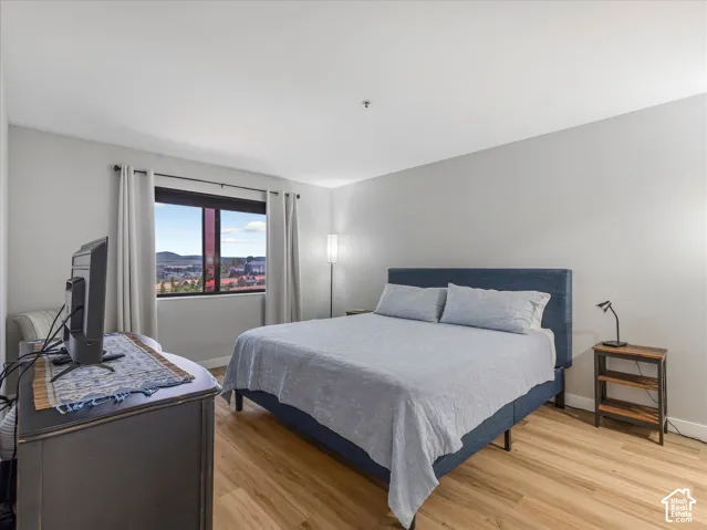 Wood-finish flooring, large window with ample natural light, and neutral wall tones