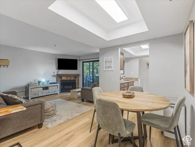 Recessed ceiling lighting, a stone-clad fireplace, wood-finish flooring, and a sliding glass door