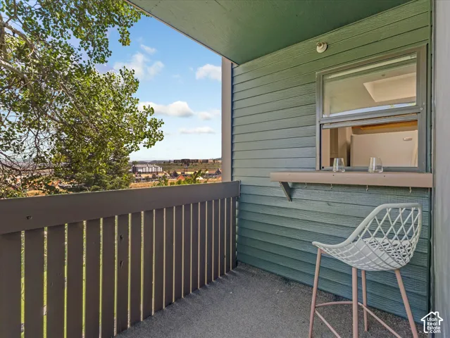 Private balcony with a slatted railing, exterior window, and a built-in shelf