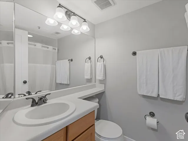 Integrated vanity with an oval sink, bronze-finish faucet, and wood-finish cabinetry