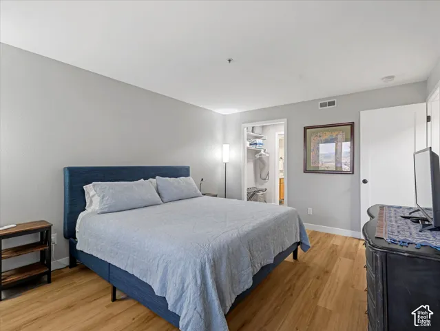 Light-toned walls, wood-finish flooring, and a recessed closet with shelving