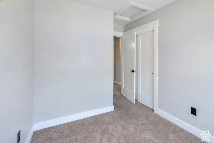 Neutral wall finish, carpeted flooring, white trim, and interior doors