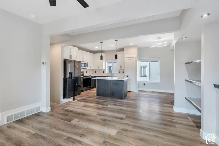 Open-concept living area featuring wood-finish flooring, recessed lighting, and built-in shelving