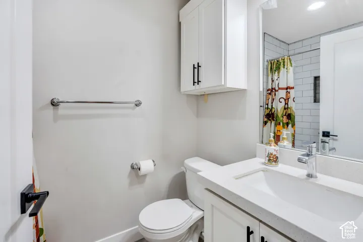 White shaker-style vanity with a light-colored countertop and integrated sink