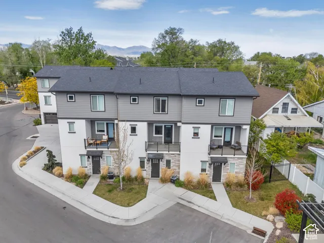 Modern townhome exterior with mixed material siding, multiple private balconies, and a dark shingle roof