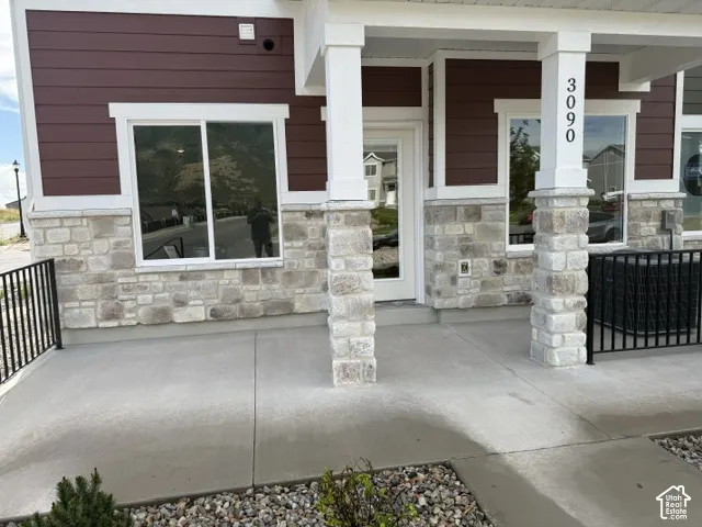 Exterior showcasing stone veneer, horizontal siding, white trim accents, and a covered porch