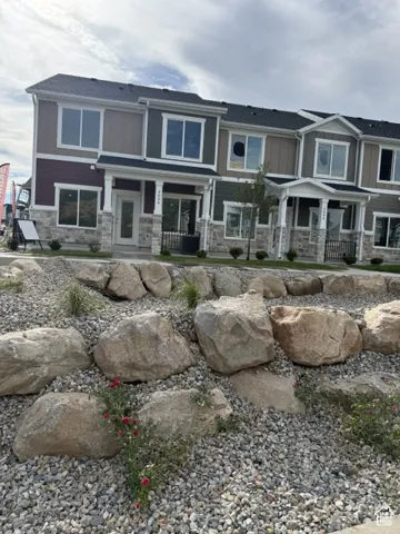 Multifaceted exterior featuring horizontal siding and stone veneer accents