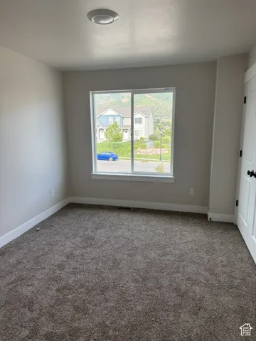 Neutral-toned wall paint, neutral-toned carpet, recessed ceiling light, white trim, and a white interior door