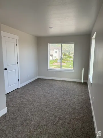 Neutral-toned carpeting, white trim, and a window with a mountain backdrop