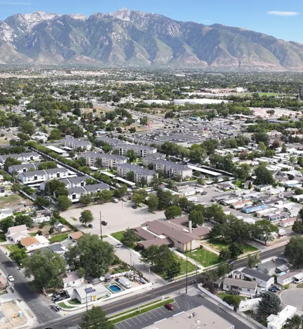 Mountainous backdrop framing a developed urban area featuring residential buildings, commercial structures, and established roadways
