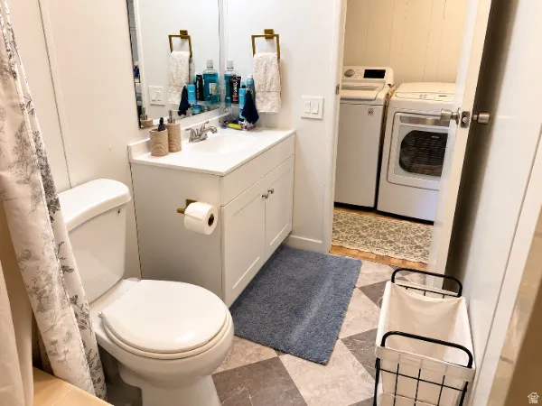 White vanity with integrated sink, gold-finish hardware, and patterned flooring
