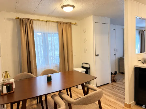 Wood-finish flooring throughout, white paneled walls, and a recessed ceiling light fixture