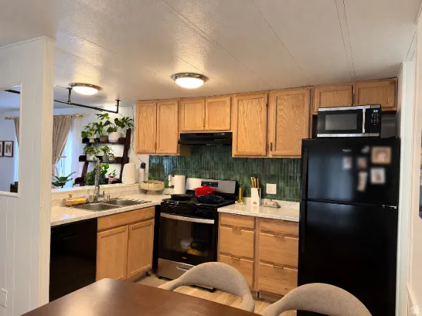 Oak cabinetry with brushed nickel hardware and a green tile backsplash