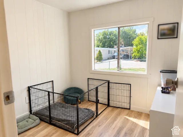 Room featuring paneling walls, wood-finish flooring, and a large window