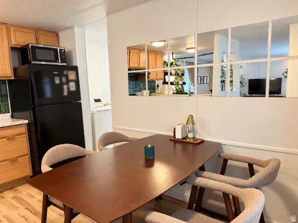 Kitchen area featuring wood-finish cabinetry, black appliances, and a tiled backsplash