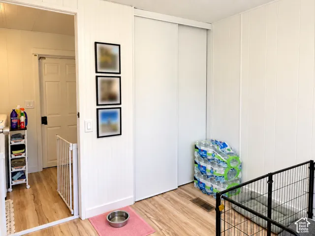 Wood-finish flooring with vertical paneling walls and white sliding closet doors