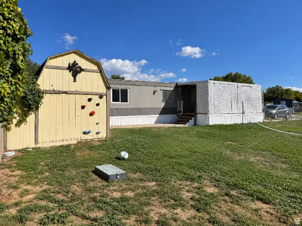 Detached storage shed with gabled roof, dedicated climbing wall, and a multi-section exterior with an enclosed porch area