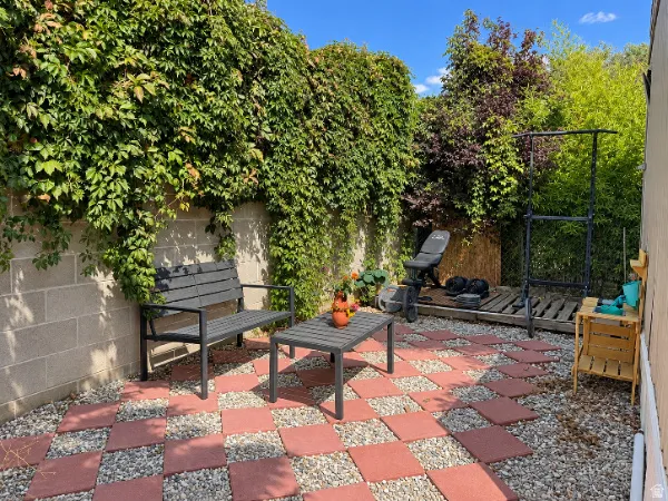 Private patio featuring checkerboard paver and gravel surfacing