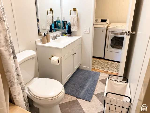 White vanity with integrated sink, gold-finish hardware, and patterned floor tile