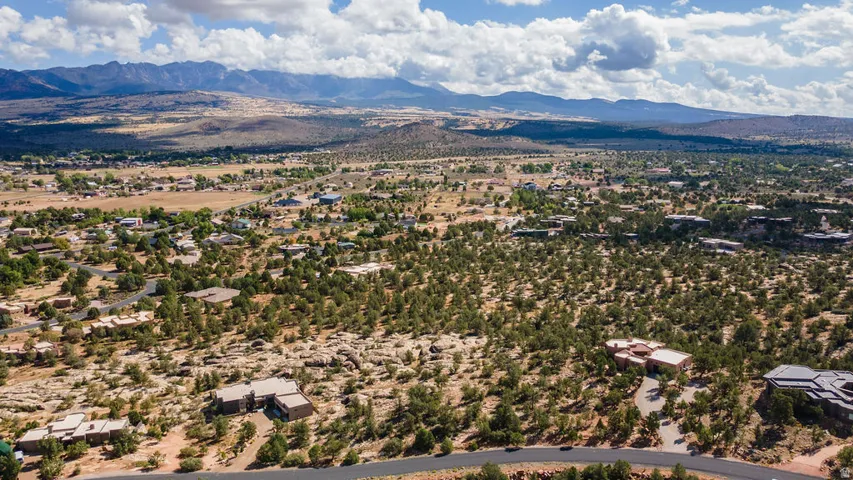 Expansive residential landscape with numerous homes nestled among mature trees, set against a backdrop of distant mountains