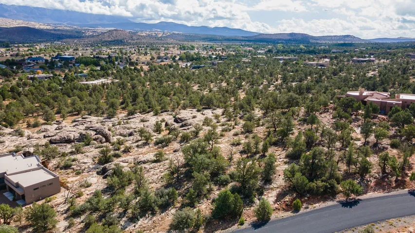 Expansive property with natural rock formations, mature trees, and mountainous terrain
