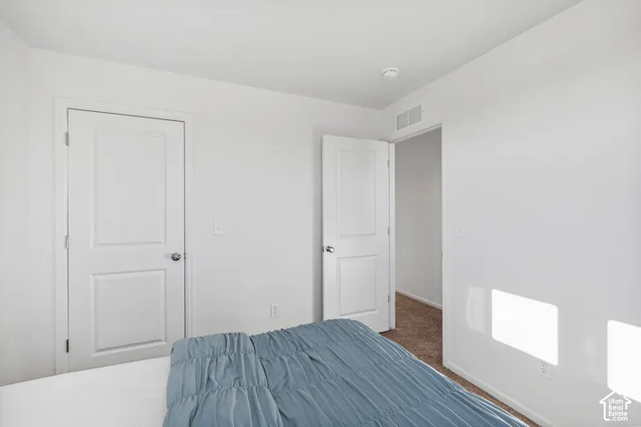 White painted walls, two-panel interior doors, and carpeted flooring