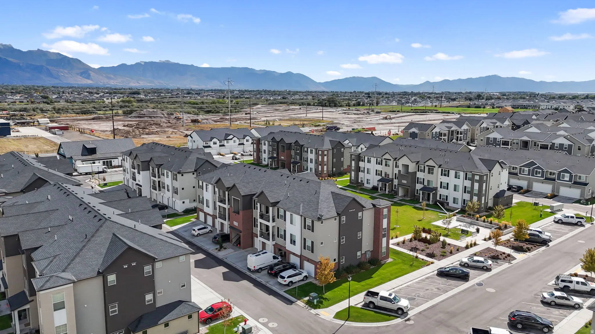 Community featuring multi-story residential buildings, paved roadways, and landscaped green spaces
