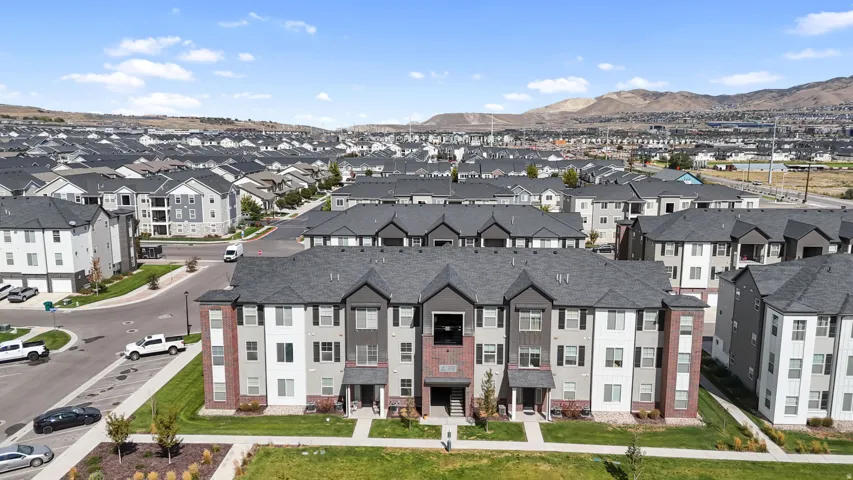 Multi-story residential buildings featuring varied siding, dark shingle roofs, and structured landscaping