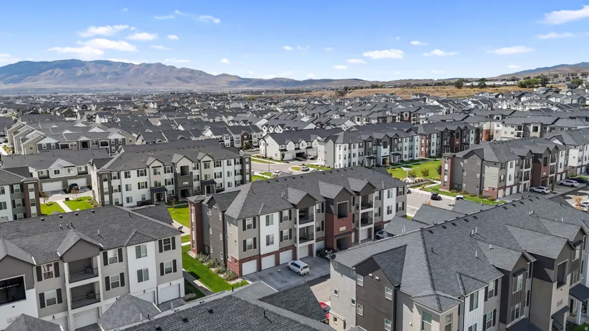 Expansive residential development featuring multi-story buildings with varied facade materials, attached garages, and private balconies
